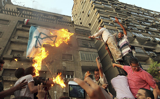 Manifestantes egpcios queimam uma bandeira de Israel em frente  Embaixada de Israel no Cairo