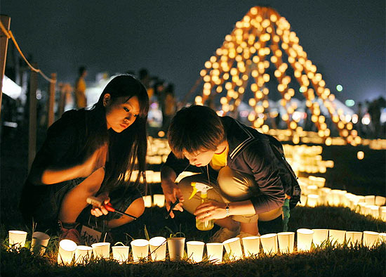 Moradores acendem velas em memria das mais de 15 mil vtimas do terremoto e tsunami de 11 de maro