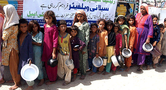 Crianças paquistanesas refugiadas aguardam distribuição de comida em Hyderabad, no Paquistão