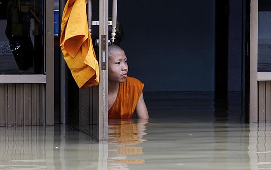 Budista de Bangcoc observa templo inundado na província de Ang Thong, na Tailândia