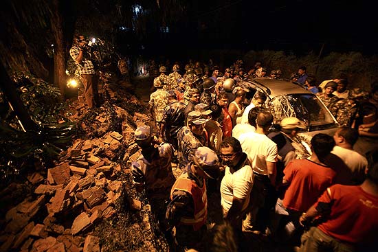 Soldados nepaleses em local onde carro ficou danificado aps muro de embaixada desabar devido a tremor