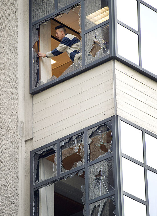 Homem inspeciona janelas quebradas pela explosão em um tribunal em Amsterdã, na Holanda