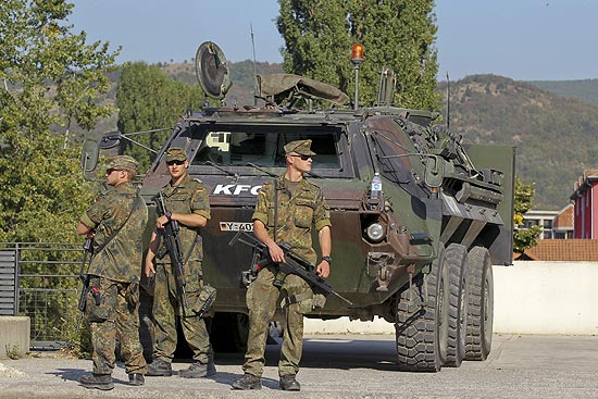 Soldados da KFOR vigiam principal ponte que divide a cidade de Mitrovica, no Kosovo