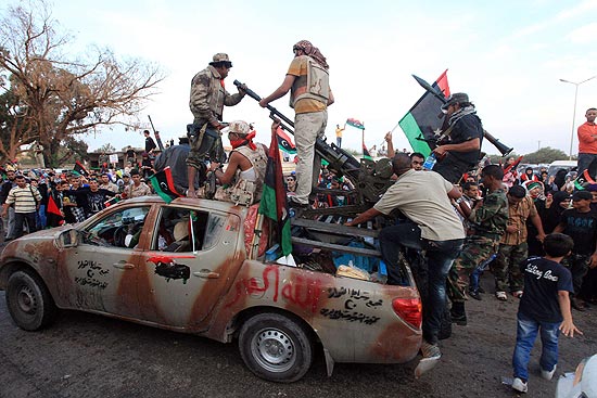 Rebeldes são recebidos em Benghazi ao retornar de Sirte, cidade onde Gaddafi foi morto na quinta-feira (20)