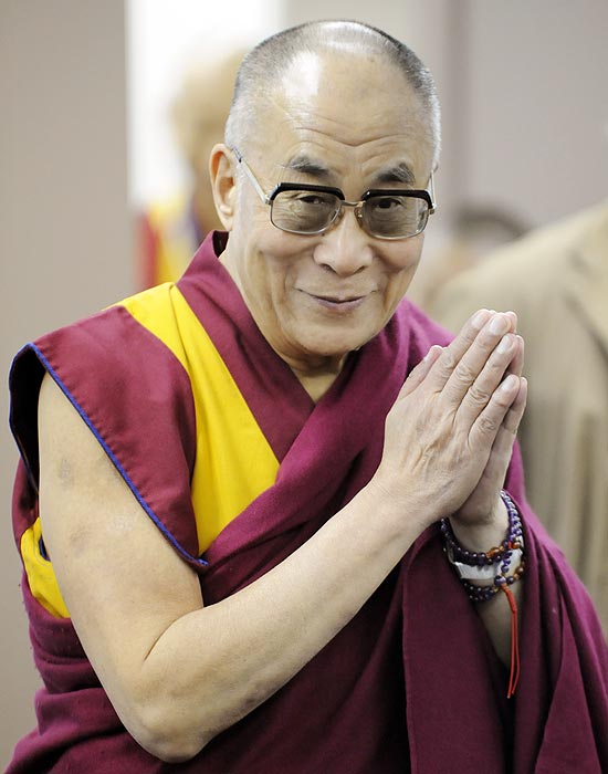 O dalai-lama saúda os jornalistas antes de começar uma coletiva de imprensa em Tóquio nesta segunda-feira