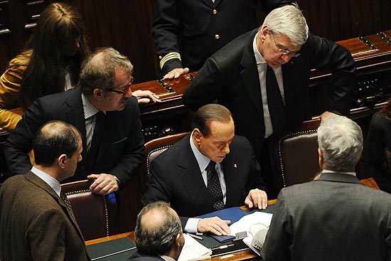 O primeiro-ministro italiano, Silvio Berlusconi, olha os números de votos após a aprovação das contas do Estado