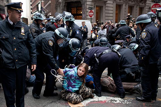 Uma participante dos protestos é presa pela polícia no distrito financeiro de Nova York