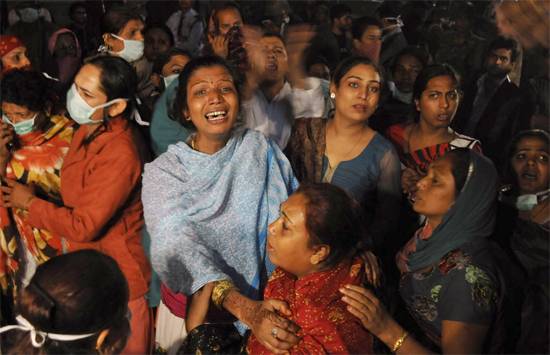 Membros da comunidade "hijra" e familiares choram a morte de ao ao menos 10 após incêndio