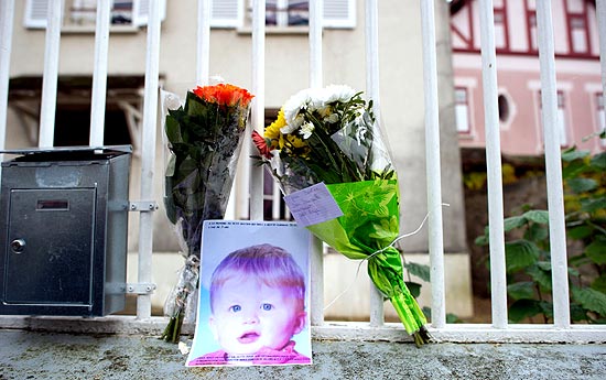 Flores são colocadas com fotografia de Bastien na entrada da casa dos pais da criança na França