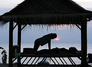 Turista recebe tradicional massagem tailandesa na praia de Bang Nieng, no litoral sul da Tailndia