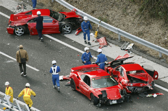 Policiais japoneses observam Ferraris destruídas em acidente que envolveu 14 carros de luxo