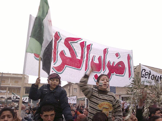 Crianças nos ombros dos pais participam de manifestação contra regime de Bashar Assad na Síria