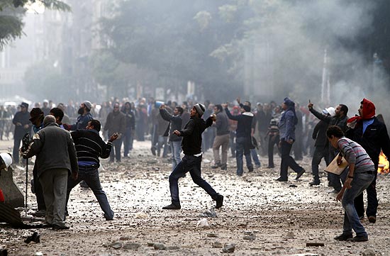 Manifestantes egípcios jogam pedras em direção às forças de segurança, na praça Tahrir, no Cairo