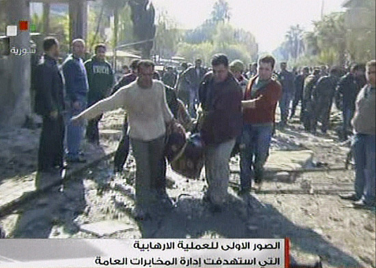 Imagem de TV mostra corpo sendo levado após explosão que atingiu dois prédios em Damasco