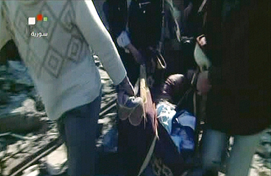 Imagem de TV mostra corpo sendo carregado após explosões em Damasco