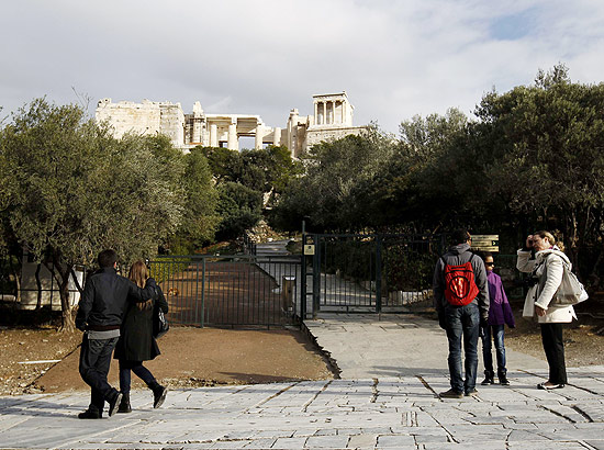 Visitantes em frente à porta fechada do Acrópolis, em Atenas