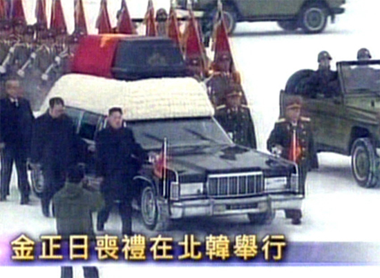 Kim Jong-un (3º a partir da esq.) e militares acompanham a pé cortejo ao lado do caixão de Kim Jong-il
