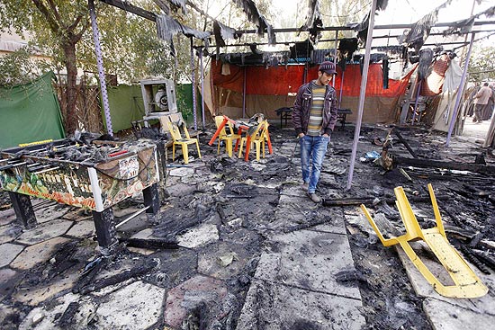 Morador observa estragos causados por ataque a bomba dentro de cafeteria em Bagd