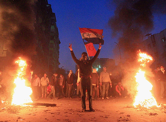 Manifestantes egpcios queimam restos de destroos de confrontos com policiais perto de ministrio 