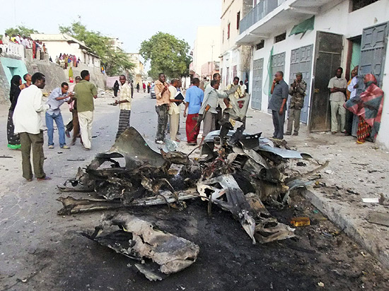 Grupo observa restos de carro-bomba em Mogadíscio, na Somália
