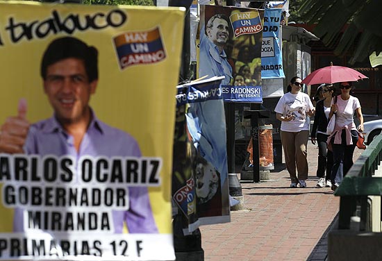Pedestres passam por cartazes eleitorais em Caracas; Venezuela escolher amanh opositor de Chvez nas prximas eleies