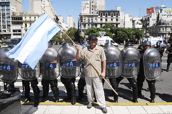 Veterano da Guerra das Malvinas segura bandeira em frente a policiais em Buenos Aires 