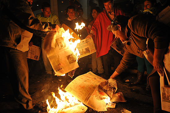 Partidrios do presidente equatoriano Rafael Correa queimam edies do jornal "El Universo" na frente do prdio do CNJ