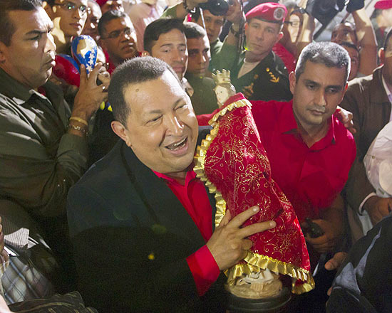 Chávez carrega um estátua da Virgem Maria na chegada a um teatro de Caracas, em véspera de viagem a Cuba
