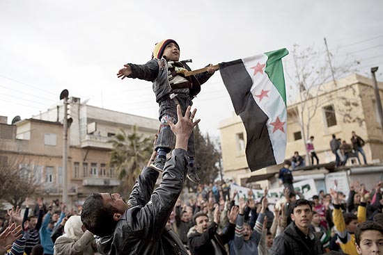 Homem segura bandeira durante manifestao contra Assad em Idlib, no norte da Sria 