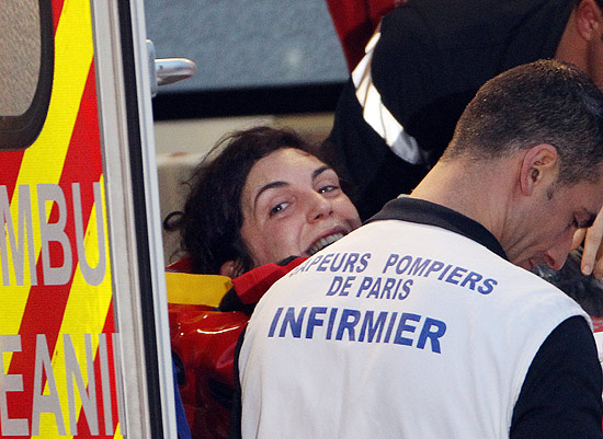 A jornalista francesa Edith Bouvier sendo levada para o hospital após chegar no aeroporto de Villacoublay