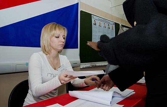 Eleitor recebe a cdula de votao em Vladivostok, na Rssia; pleito para presidencial tem Putin como favorito