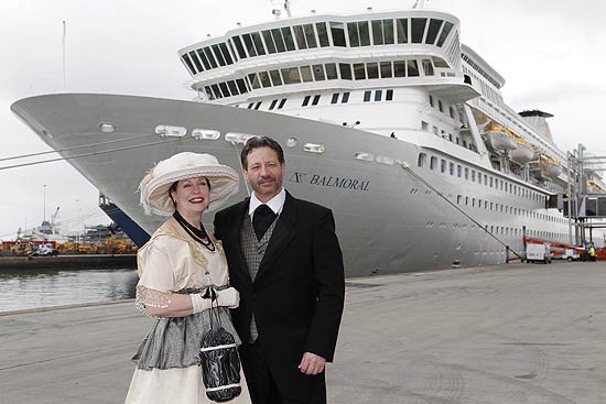 Vestindo trajes de época, casal posa em frente ao navio do Titanic Memorial Cruise, que saiu de Southampton