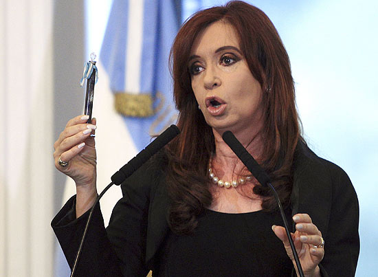 A presidente Cristina Kirchner segura tubo com petróleo, durante anúncio de intervenção na YPF, em Buenos Aires