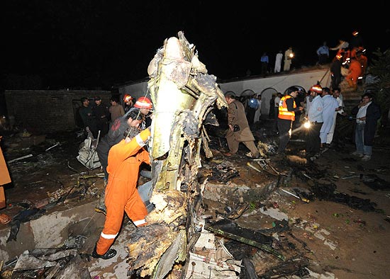 Equipes e moradores no local onde avião caiu no Paquistão; 127 a bordo morreram