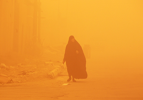 Mulher tenta andar em meio a tempestade de areia em Bagd, no Iraque, nesta tera-feira