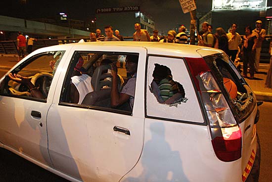 Carro de imigrante africano tem as janelas destruidas por manifestantes em Tel Avivi