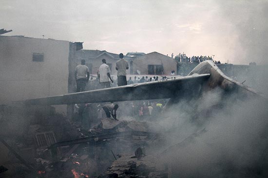 O resgate busca os corpos das vítimas nos destroços do avião que caiu em Lagos; mais de 150 morreram