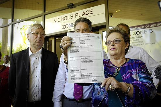 Linda Chamberlain-Creighton e Michael Chamberlain mostram o atestado de óbito de sua filha Azaria