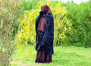 Aluna usando niqab fala ao telefone na Universidade Manouba