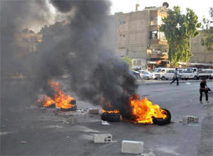 Imagem fornecida por opositores srios mostram bloqueio em Jobar, na vizinhana de Damasco, com pneus queimados
