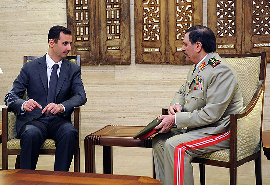 Imagem divulgada pela TV estatal sria mostra Assad ( esq.) ao lado de Fahd al-Freij, novo ministro da Defesa