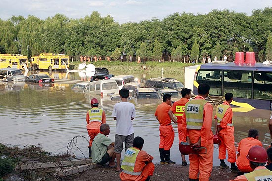 Equipes de resgate tentam tirar motoristas e passageiros de carros inundados em rodovia de Pequim