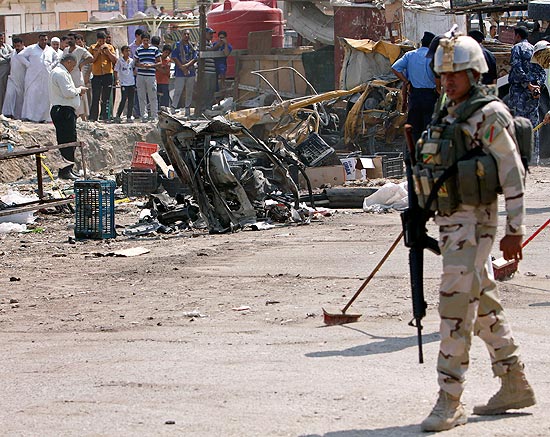 Soldado vigia cena de explosão de carro-bomba em Basra; atentados matam ao menos 31 no Iraque