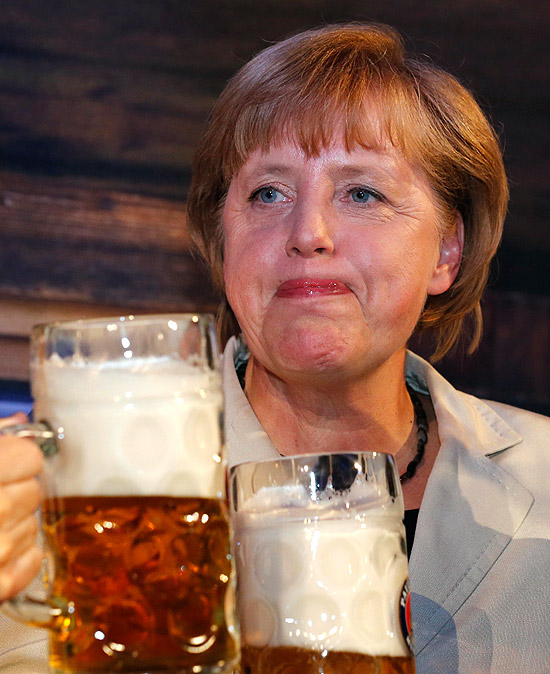 A chanceler alemã Angela Merkel bebe em Oktoberfest em Berlim