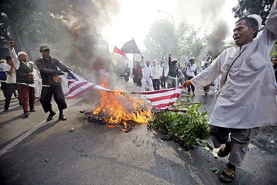 Manifestantes seguram bandeira americana em chamas, durante protesto contra filme anti-isl em Jacarta, Indonsia
