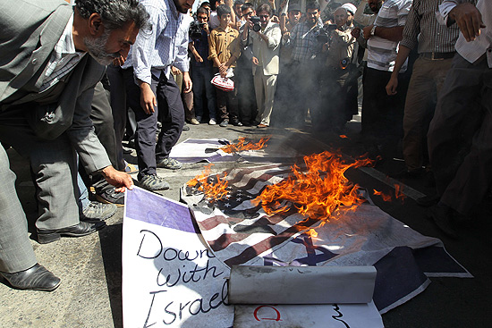 Homem queima bandeiras dos Estados Unidos e de Israel em protesto em frente  embaixada da Frana em Teer