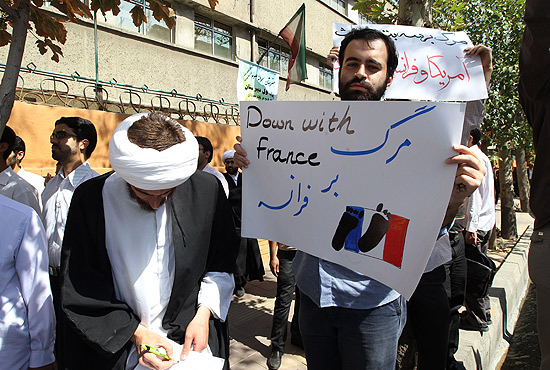 Homem carrega cartaz contra a Frana em protesto em Teer nesta quinta-feira; ato no foi violento