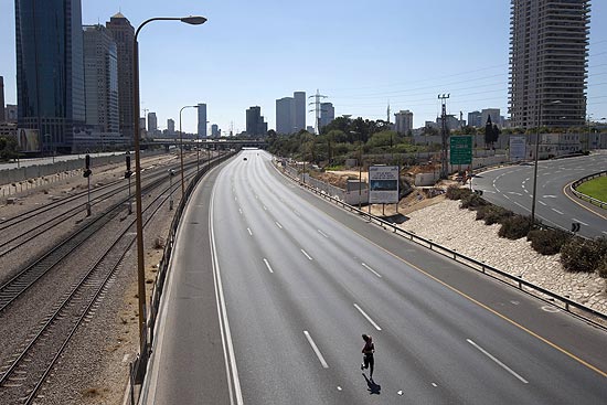 Mulher se exercita em uma via-expressa vazia de Tel Aviv, em Israel, durante feriado de Yom Kippur