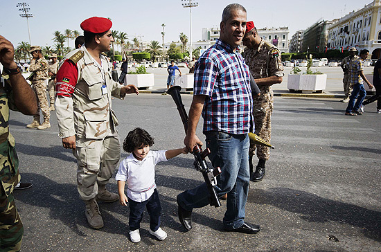Homem caminha de mos dadas com criana e participa de campanha do desarmamento em Trpoli, na Lbia