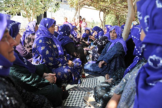 Mulheres com véus roxos, em sinal de luto, participam de velório de vítimas de bombardeio sírio na Turquia